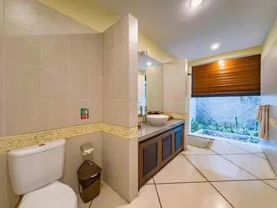 a bathroom with a toilet and a sink and a window at Luxury 4BR - Villa Santai - Central Seminyak in Seminyak