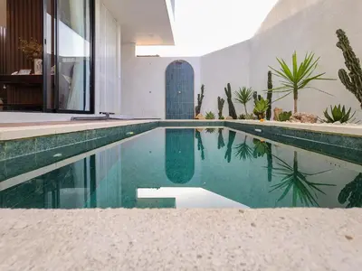 a swimming pool in the middle of a house at Villa Sorano Seminyak by Nagisa Bali in Seminyak