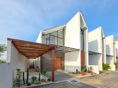 a white house with a wooden pergola at Villa Sorano Seminyak by Nagisa Bali in Seminyak