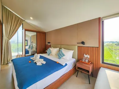 a bedroom with a large bed with towels on it at Villa Sorano Seminyak by Nagisa Bali in Seminyak
