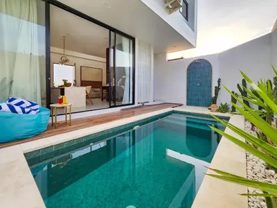an indoor swimming pool in a house at Villa Sorano Seminyak by Nagisa Bali in Seminyak