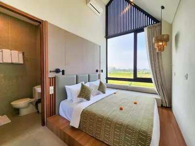 a bedroom with a large bed with a large window at Villa Sorano Seminyak by Nagisa Bali in Seminyak