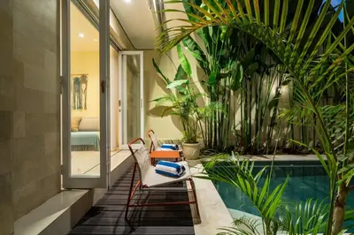 a patio with a pool and chairs and plants at Prime Location Seminyak 3BR Pool Villa in Seminyak