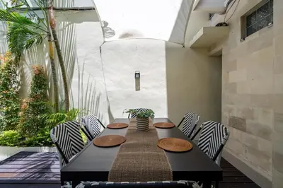 a black table and chairs in a room with a patio at Prime Location Seminyak 3BR Pool Villa in Seminyak
