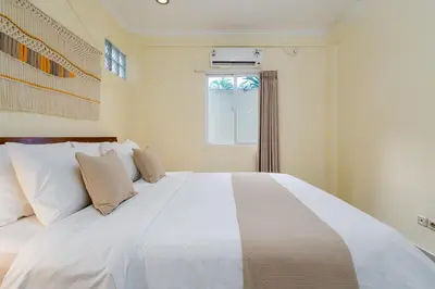 a large white bed in a room with a window at Prime Location Seminyak 3BR Pool Villa in Seminyak