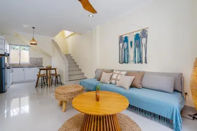 a living room with a blue couch and a table at Prime Location Seminyak 3BR Pool Villa in Seminyak