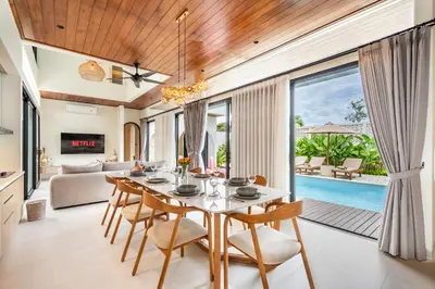 a dining room with a table and chairs and a pool at Jivani Villa - 9 min to Nusa Dua Beach - Brand New, Cinema Room, BBQ, 3Bdr in Jimbaran