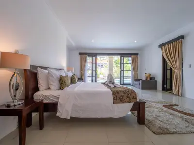 a large bedroom with a bed and a couch at Villa Cometa Luxury Seminyak by Adam Jyota Management in Seminyak