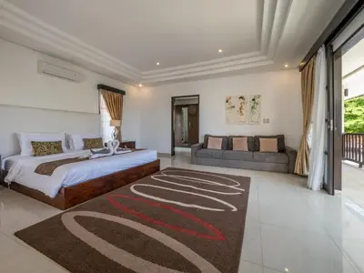 a bedroom with a large bed and a couch at Villa Cometa Luxury Seminyak by Adam Jyota Management in Seminyak