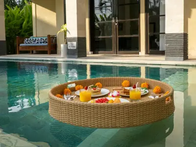 a table with food and drinks in a swimming pool at Villa Cometa Luxury Seminyak by Adam Jyota Management in Seminyak