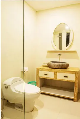 a bathroom with a toilet and a mirror at Bali Balitung in Seminyak