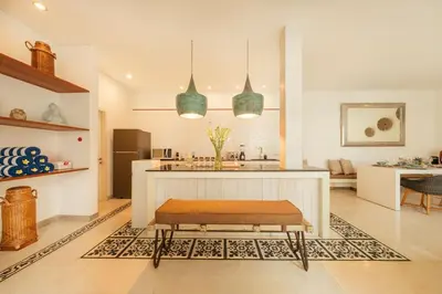 a kitchen with a bench in the middle of a room at Stylish 3BR Escape, 5 Mins to Seminyak Beach in Seminyak