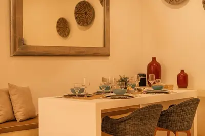 a dining room table with wine glasses and a mirror at Stylish 3BR Escape, 5 Mins to Seminyak Beach in Seminyak