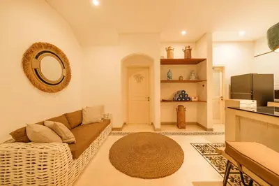 a living room with a couch and a kitchen at Stylish 3BR Escape, 5 Mins to Seminyak Beach in Seminyak