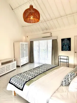 a bedroom with a large bed and a large window at Wangi Melati Homestay in Kerobokan