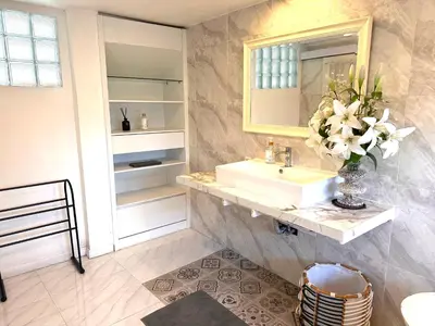a bathroom with a sink and a vase of flowers at Wangi Melati Homestay in Kerobokan