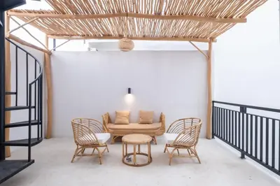a living room with a couch and four chairs at La Casa Gomes in Nusa Dua