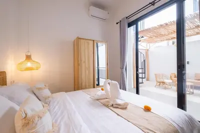 a bedroom with a large white bed with towels on it at La Casa Gomes in Nusa Dua