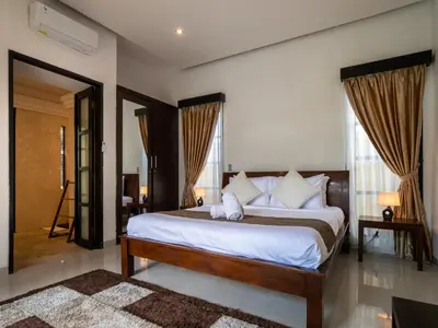 a bedroom with a large bed with white sheets at Villa Cometa Prime Seminyak by Adam Jyota Management in Seminyak