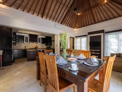 a dining room and kitchen with a table and chairs at Villa Cometa Prime Seminyak by Adam Jyota Management in Seminyak
