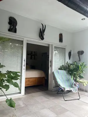 a bedroom with a bed and a chair in a room at Villa Harmony Moon in Denpasar