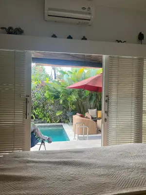 a bedroom with a view of a swimming pool through the door at Villa Harmony Moon in Denpasar