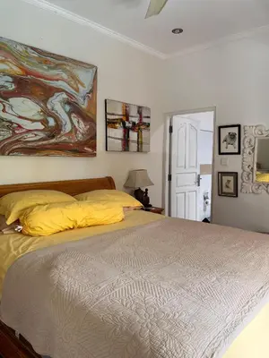 a bedroom with a bed and a painting on the wall at Villa Harmony Moon in Denpasar