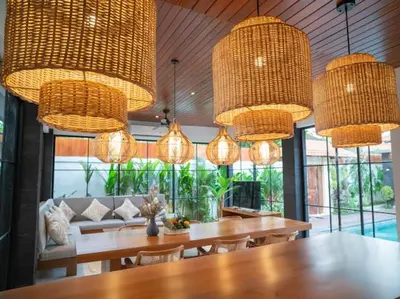 a dining room with tables and chairs and chandeliers at Harbie Villa 2 in Badung