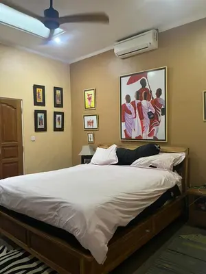 a bedroom with a large bed and a painting on the wall at Villa Harmony Moon in Seminyak