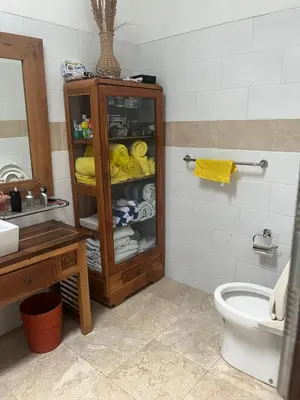 a bathroom with a toilet and a cabinet with towels at Villa Harmony Moon in Seminyak