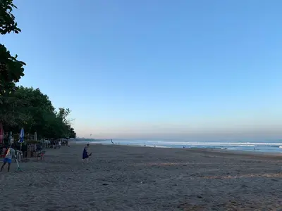 a group of people walking on the beach at The Jayakarta Residence 2BR Bali in Denpasar