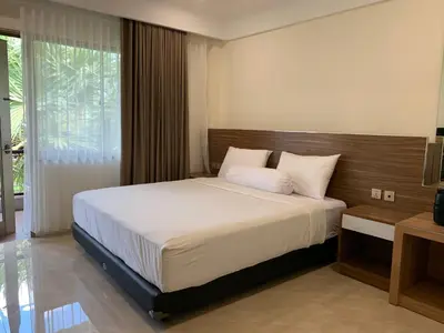 a bedroom with a large bed in a room at The Jayakarta Residence 2BR Bali in Denpasar