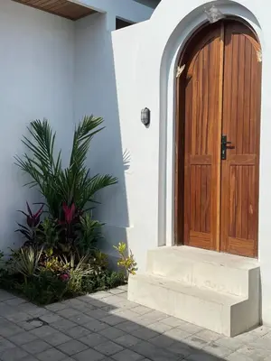 a wooden door on the side of a house at Villa Jiji cozy chic in Bali - just renovated ! in Canggu