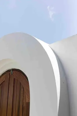 an archway in a white building with a wooden door at Villa Jiji cozy chic in Bali - just renovated ! in Canggu