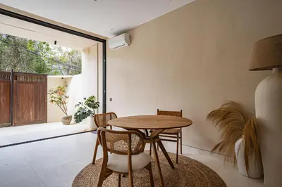 a dining room with a wooden table and chairs at Villa Nazare Berawa in Canggu