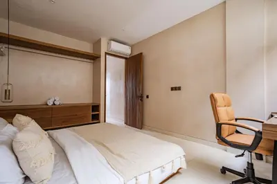 a bedroom with a bed and a desk and a chair at Villa Nazare Berawa in Canggu