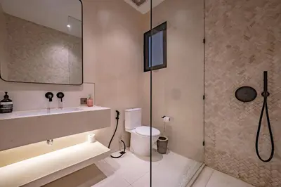 a bathroom with a shower and a toilet and a sink at Villa Nazare Berawa in Canggu