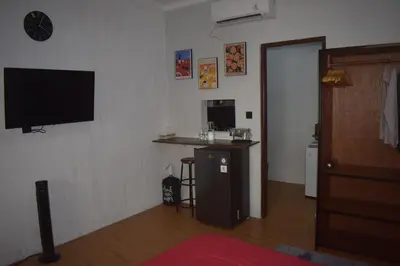 a living room with a flat screen tv on the wall at Banana Room Near to Kuta Legian Beach in Legian