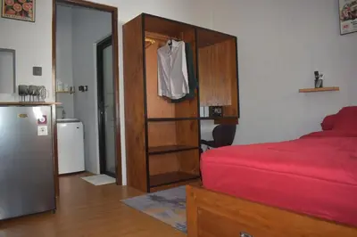 a bedroom with a red bed and a wooden closet at Banana Room Near to Kuta Legian Beach in Legian