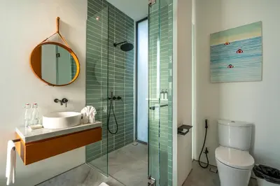 a bathroom with a sink and a shower with a mirror at Villa Semilir Sendja, Canggu in Canggu
