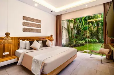 a bedroom with a large bed and a large window at Feodora Peaceful 4 BR Private Pool Villa in Seminyak