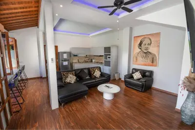 a living room with black couches and a ceiling fan at Villa Kartini - Two Bedrooms in Legian