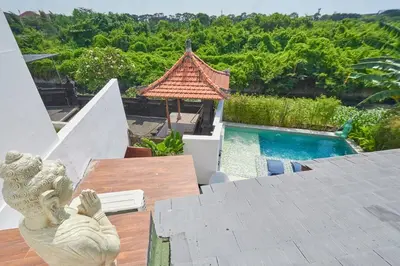 a statue sitting on a table next to a swimming pool at Villa Kartini - Two Bedrooms in Legian