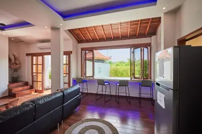 a living room with a couch and a table and chairs at Villa Kartini - Two Bedrooms in Legian
