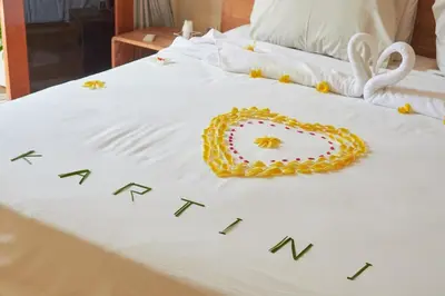 a bed with a white blanket with a wreath on it at Villa Kartini - Two Bedrooms in Legian