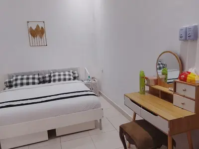 a white bedroom with a bed and a desk at Kuta Grace house Bali in Kuta