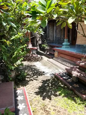 a building with trees in front of a building at Kuta Grace house Bali in Kuta