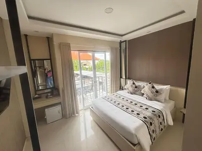 a bedroom with a bed and a balcony at Ultimate Residence in Seminyak