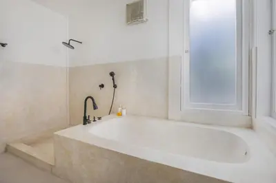 a white bath tub in a bathroom with a window at Villa Stella Belle Seminyak in Seminyak