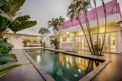 an indoor pool in a house with palm trees at Villa Stella Belle Seminyak in Seminyak